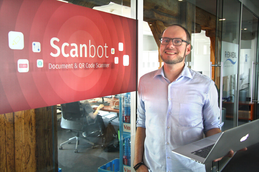 Digitale Leute - Michael Stache - Scanbot - Michael Stache vor dem Scanbot Logo